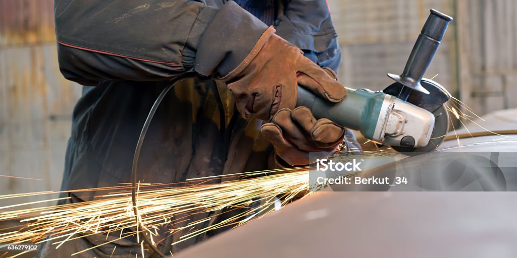 Sparks when machining a weld bead on the pipe The welder handles the root seam with a cutting machine. Preparing for the facing seam to the control sample. Factory Stock Photo