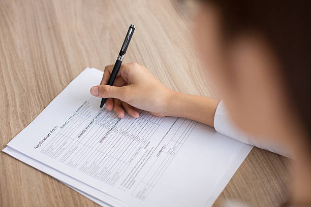 istock Closeup of Female Applicant Completing Form 636279534