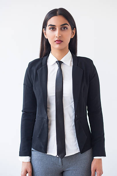 Closeup of Serious Elegant Indian Female Student Closeup portrait of serious young elegant Indian female student standing and looking at camera. Isolated front view on white background. woman necktie stock pictures, royalty-free photos & images