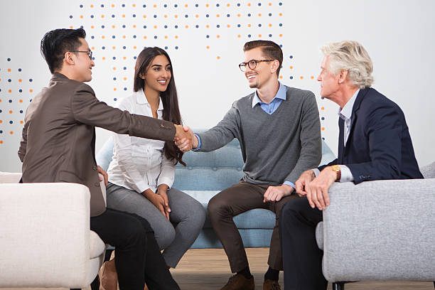 istock Smiling Business Partners Shaking Hands in Lounge 636279704