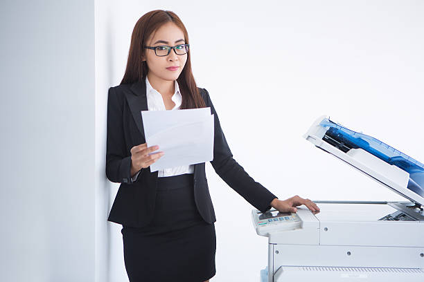 istock Young Asian Business Lady Using Photocopier 636282514