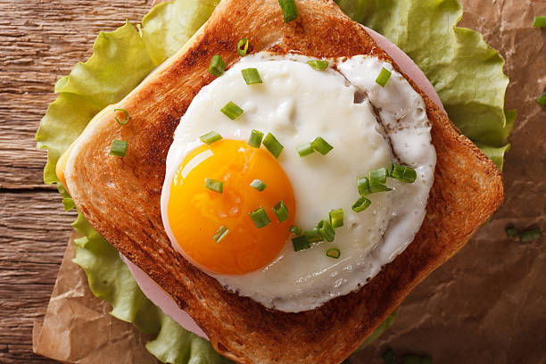 istock Sandwich with fried egg, ham, onions and cheese closeup 636287054