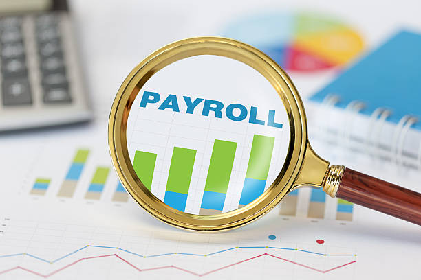 magnifying glass and calculator on payroll graph - finance financial figures graph chart imagens e fotografias de stock