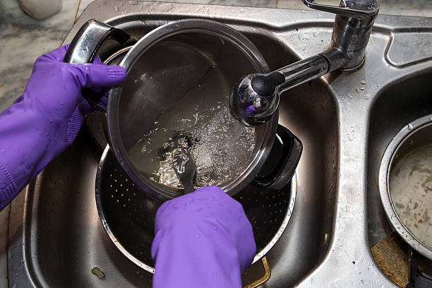 istock Washing dishes in purple gloves 636289540