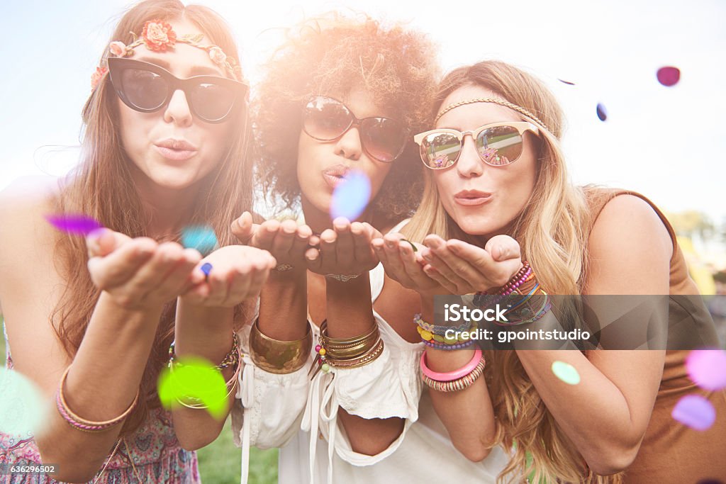 Girls blowing some confetti pieces Coachella Valley Stock Photo
