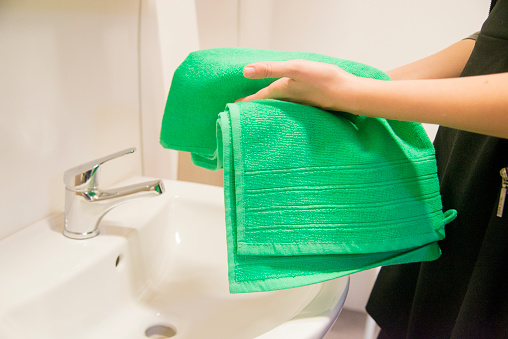 Woman drying her hands with green towel