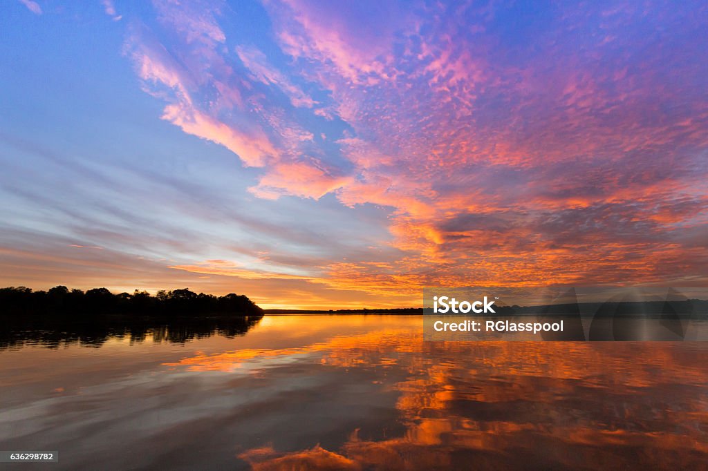 Zambezi Sunset, Matetsi, Zimbabwe The dramatic sunset from the Zambezi River.  Sunsets like these are common during the rainy season once a storm has passed. The picture was taken from the boat of andBeyond Matetsi which based in the Lower Zabezi National Park in Zimbabwe.  The lodge is 40km up river from Victoria Falls. Mosi-Oa-Tunya Waterfall Stock Photo