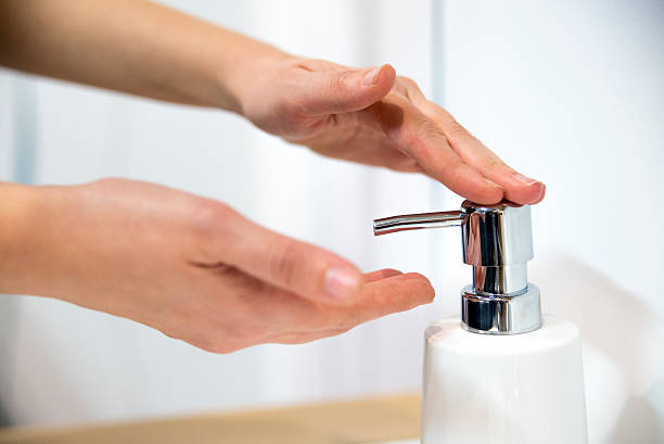 Female hands applying liquid soap close up