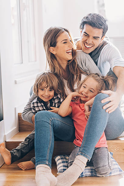 Happy young family with two small children Happy young family with two small children - boy and girl, sitting on the floor and holding. two parents photos stock pictures, royalty-free photos & images