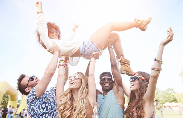 Excited woman crowd surfing at music festival Excited woman crowd surfing at music festival mosh pit stock pictures, royalty-free photos & images