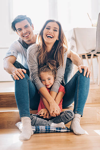 felice giovane famiglia a casa - floor two parent family couple home interior foto e immagini stock