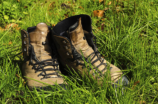 The hiker is seen resting in a grassy field on a bright day after a long walk.