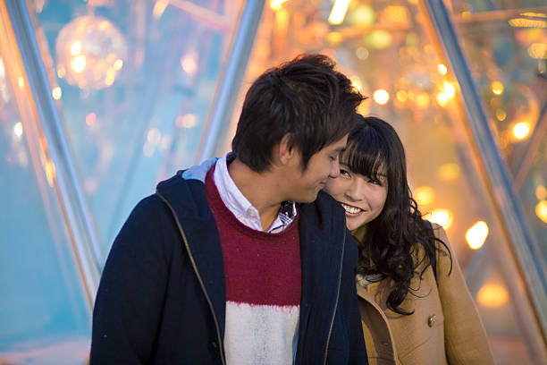 istock Young couple looking at each other in Christmas lights 636303956