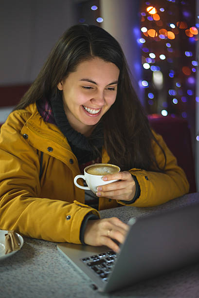 istock woman sitting with laptop in cafe 636304124