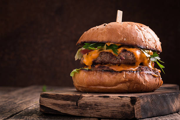 istock Tasty grilled burger with lettuce and mayonnaise , rustic wooden table 636305290