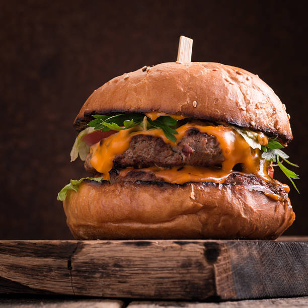istock Tasty grilled burger with lettuce and mayonnaise , rustic wooden table 636305334