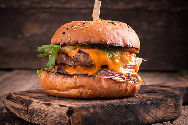 istock Tasty grilled burger with lettuce and mayonnaise , rustic wooden table 636305382