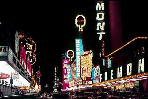 Las Vegas, Nevada, USA, June 29, 1968. Las Vegas at Night. The Fermont Street. On the right is the Fremont Hotel Casino and on the left the four Queens Casino. In between the car traffic in the famous Fermont St.