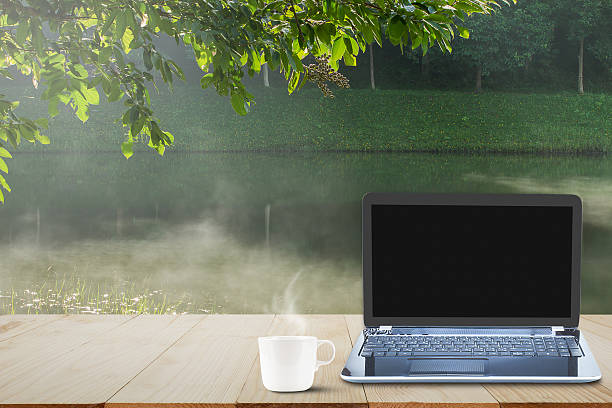 istock Computer laptop, coffee cup on wooden table top,  business concept 636309540
