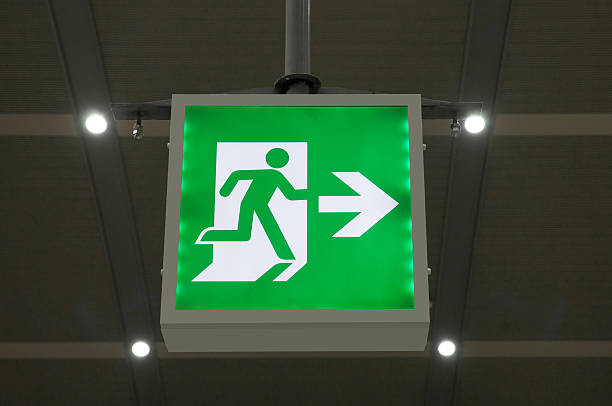 istock green emergency exit sign showing the way to escape. 636309582