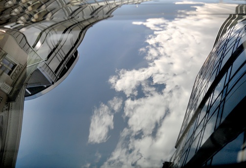 Reflection of the sky and buildings around in the glass of car