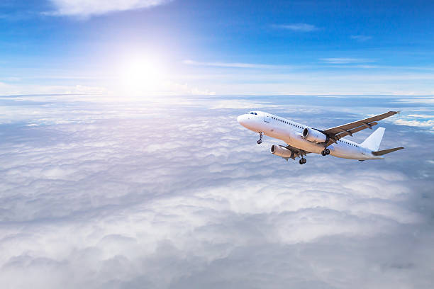 istock airplane flying in sky high altitude above white clouds 636314632