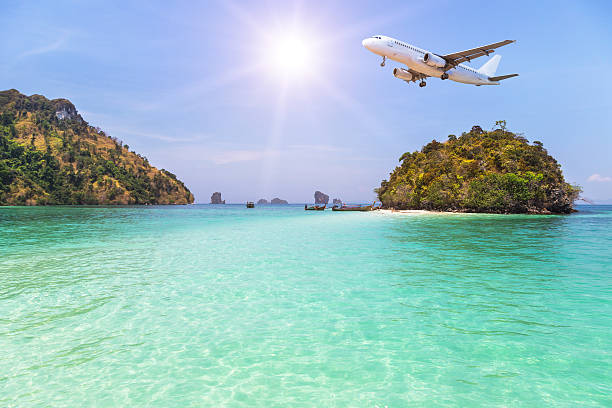 istock airplane flying above small island in tropical sea with sunlight. 636314696