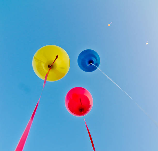 ballons colorés dans le ciel bleu - sun sky child balloon photos et images de collection
