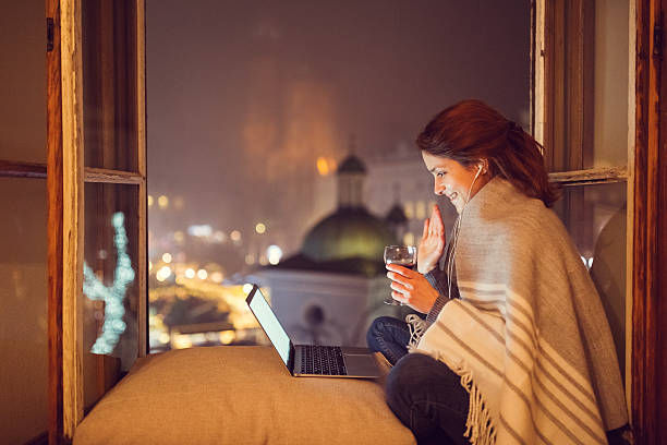 mujer joven en casa disfrutando de una videollamada - internet dating fotografías e imágenes de stock