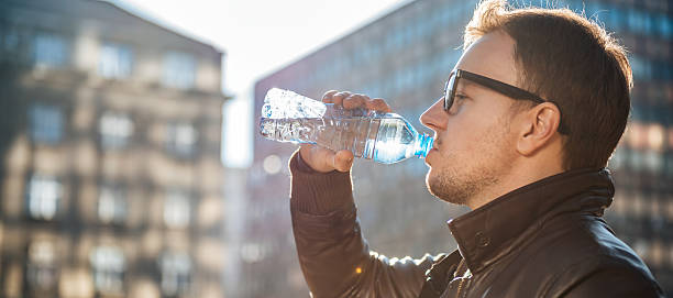istock Man drinking water in the city 636321278