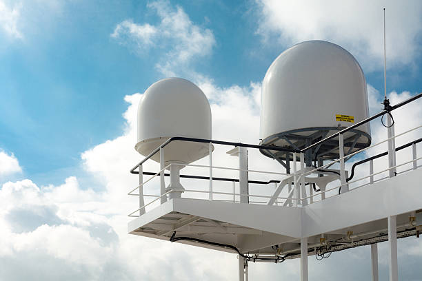 Satellite receiver  and radar dome on bridge of large industrial ship on river