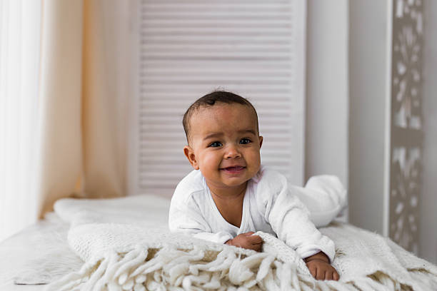 istock Laughing Mixed Race Baby Boy Lying On Tummy At Home 636324600