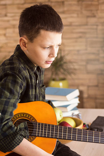 istock Sad Thoughtful Boy With Acoustic Guitar 636327108