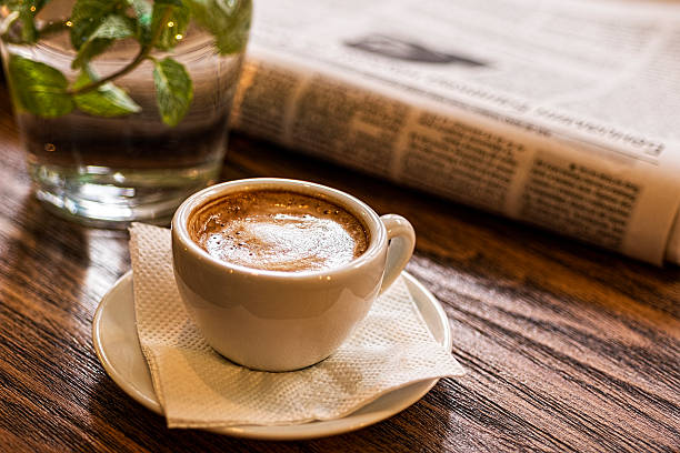istock Coffee Cup, Water and Newspaper on Wooden Table. Good Morning. 636327718