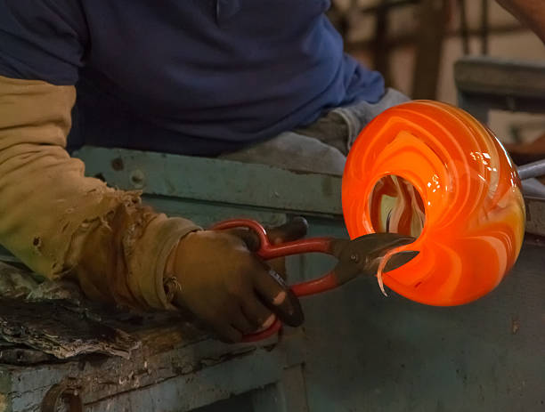 traditional glassblowing worker cutting liquid glass traditional glassblowing worker cutting liquid glass murano stock pictures, royalty-free photos & images