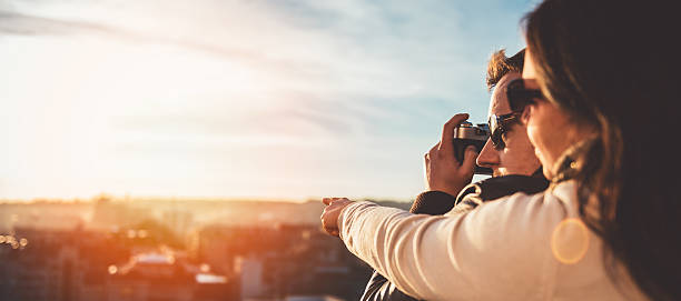 couple taking pictures on the rooftop - love couple city life urban scene imagens e fotografias de stock