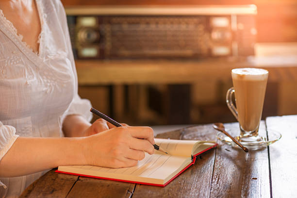 femme qui travaille écrit une note dans un café de style vintage - fresh coffee audio photos et images de collection