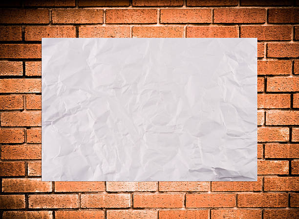 istock white crumpled paper on orange brick wall background 636332490