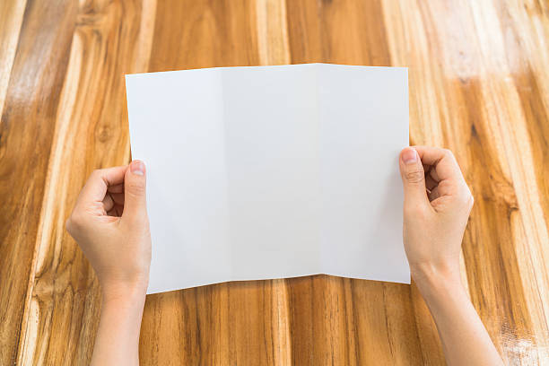 istock Woman holding a folded blank paper 636333646