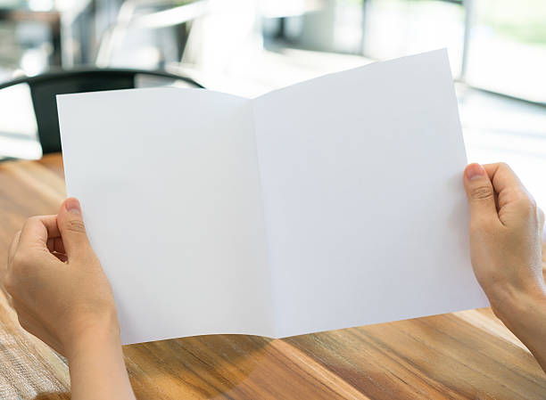 istock Woman holding a folded blank paper 636333714