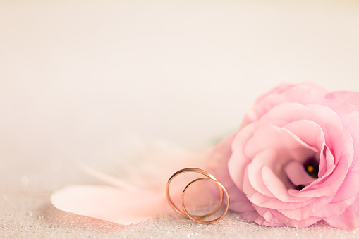Fondo de la boda con anillos de oro, flor suave y pasador de luz photo