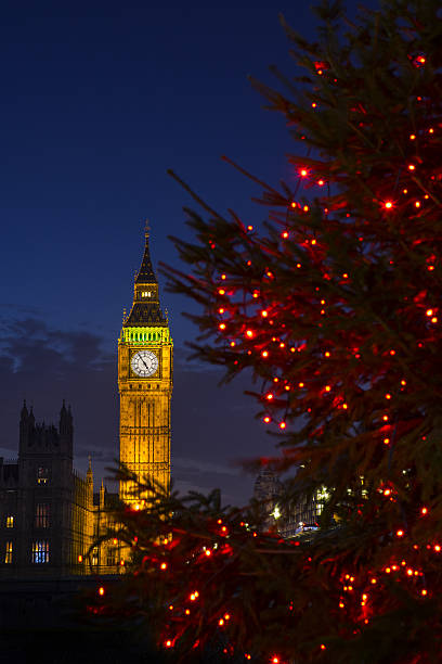 Big Ben at Christmas A view of a beautiful illuminated Christmas tree with the Elizabeth Tower of the Houses of Parliament in the background, London. big ben stock pictures, royalty-free photos & images