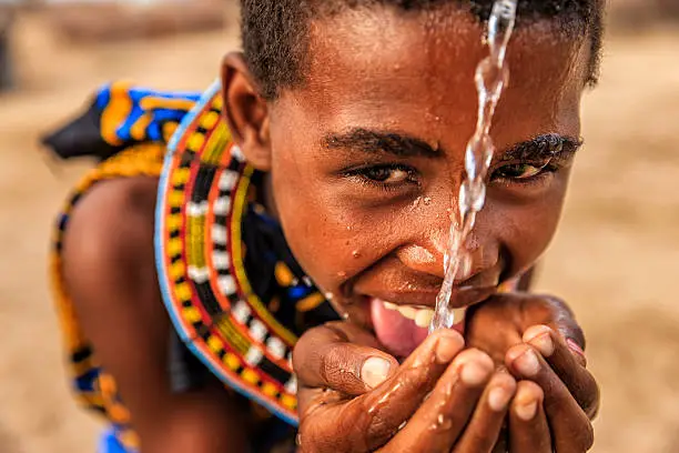 Photo of African little girl from Samburu tribe drinking fresh