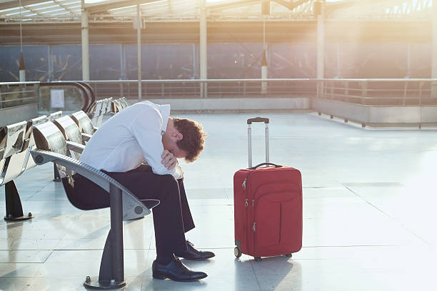istock flight delay in airport, tired troubled man with luggage 636336370