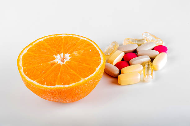 istock Fruits vs synthetic vitamins on white background 636339450