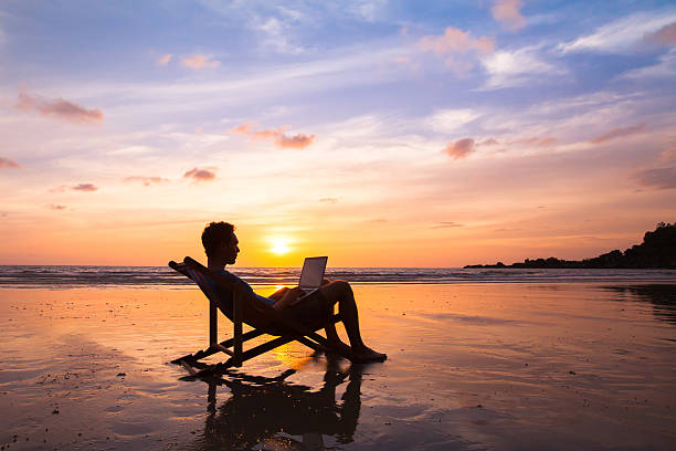 geschäftsmann mit laptop am strand arbeiten - beach ideas stock-fotos und bilder