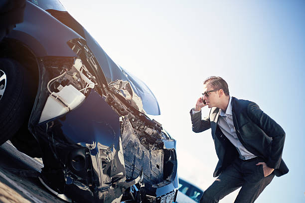 istock Adult man in a suit checking damage after car crash 636343300