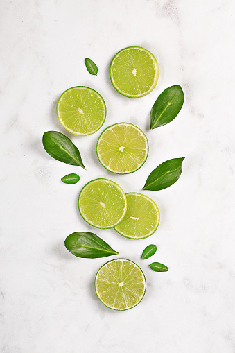 Ripe lime with a half on white background. High angle view.