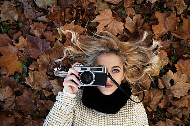 Beautiful girl taking photos with retro camera
