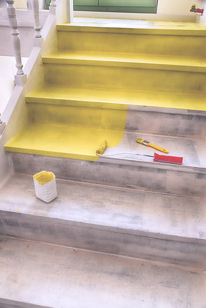 istock Painting stairs with brush and roller in yellow 636348780